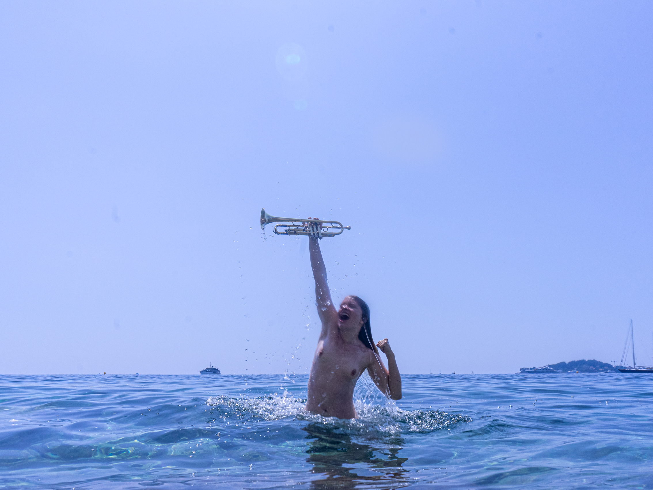 La victoire, série Ode à la joie, 2019 — une femme debout dans la mer brandit une trompette vers le ciel