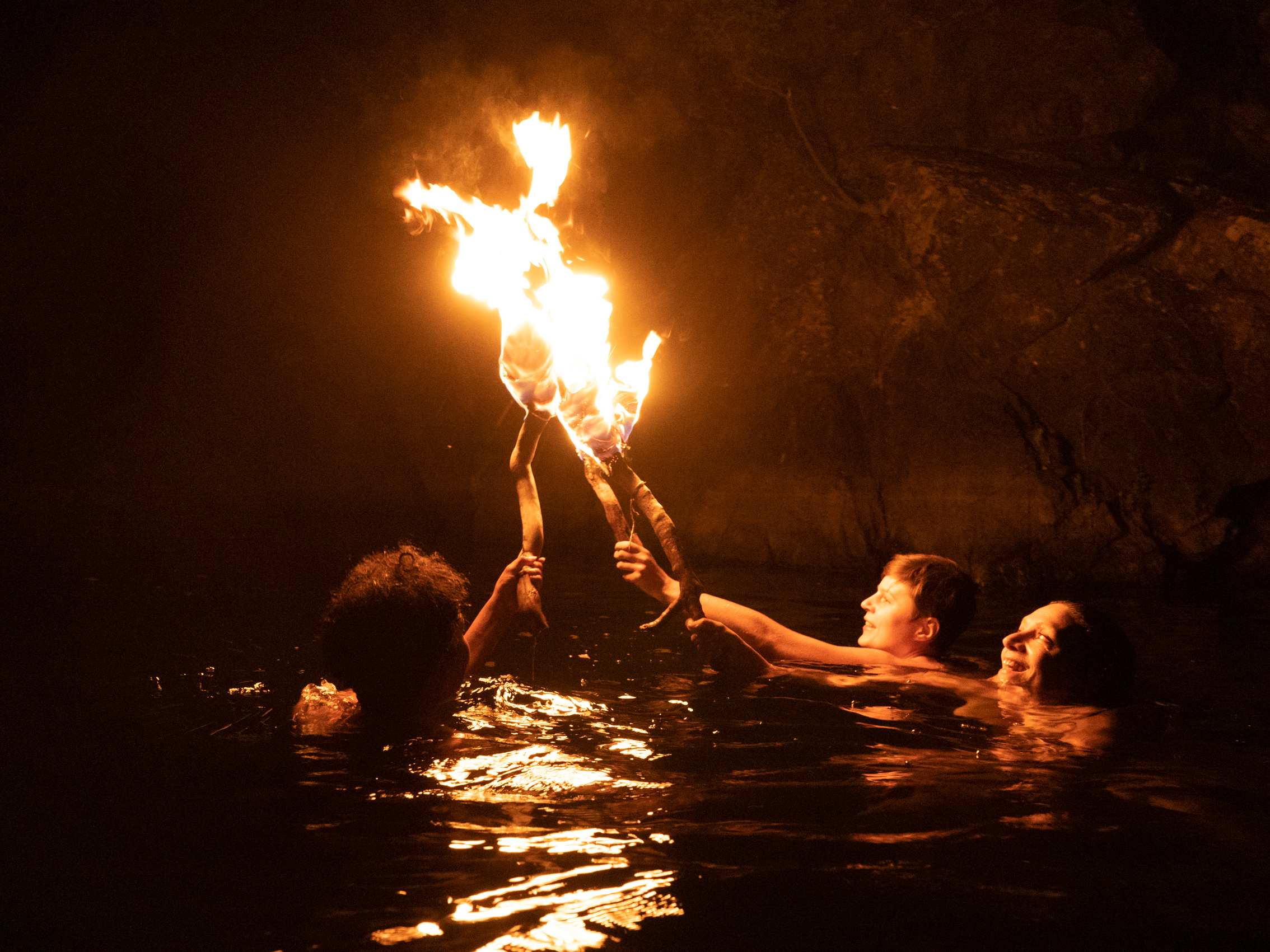 le feu sur l'eau Le feu sur l'eau, série Ode à la joie, 2019 — de nuit, trois nageurs élèvent ensemble une flamme au-dessus de l'eau